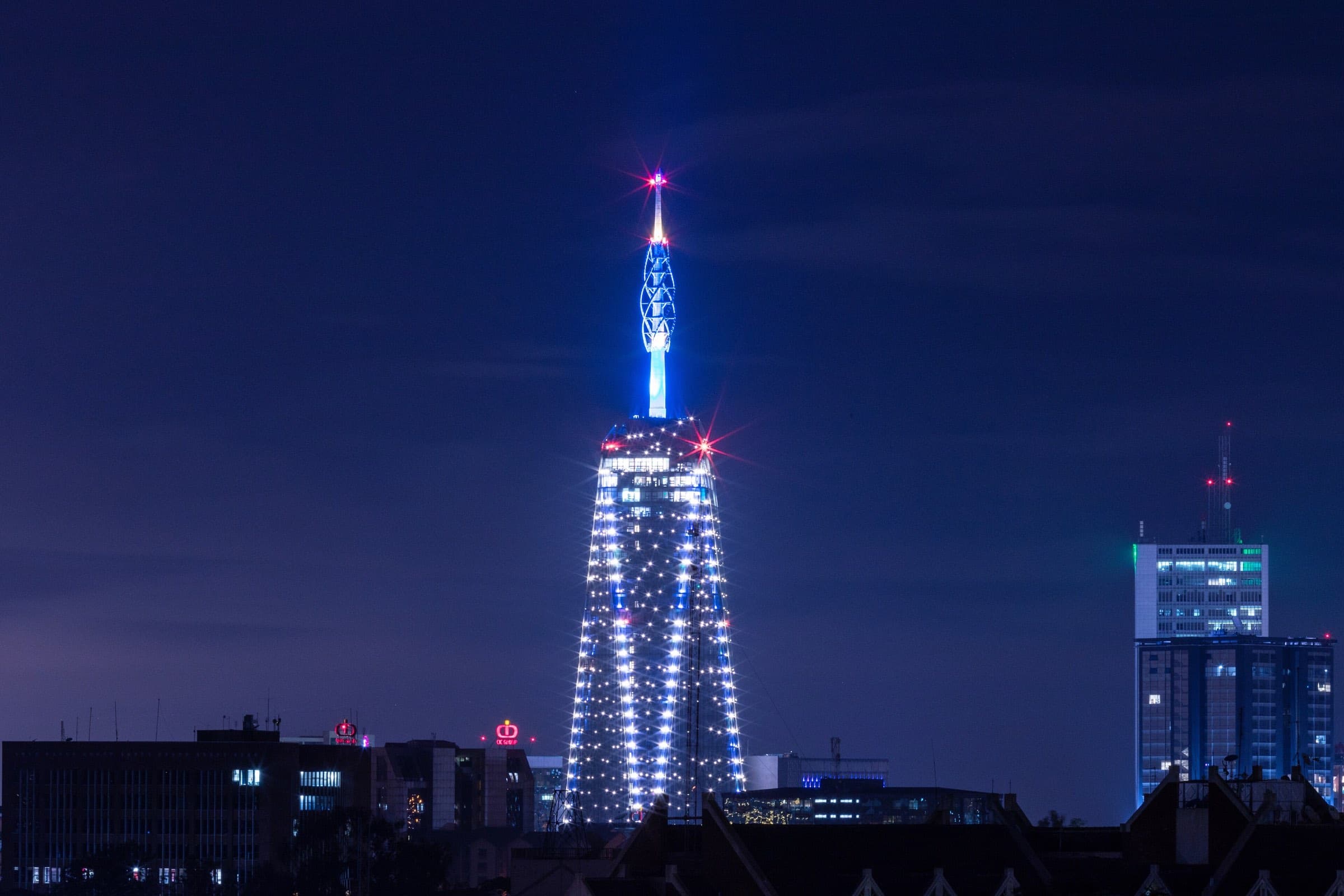 The illuminated Britam Tower lighting up the Nairobi skyline at night